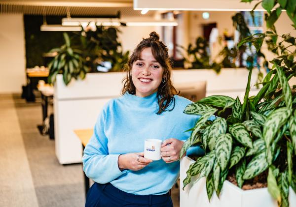 Medewerker met koffiemok in de hand